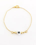 Pulsera dorada inicial blanca